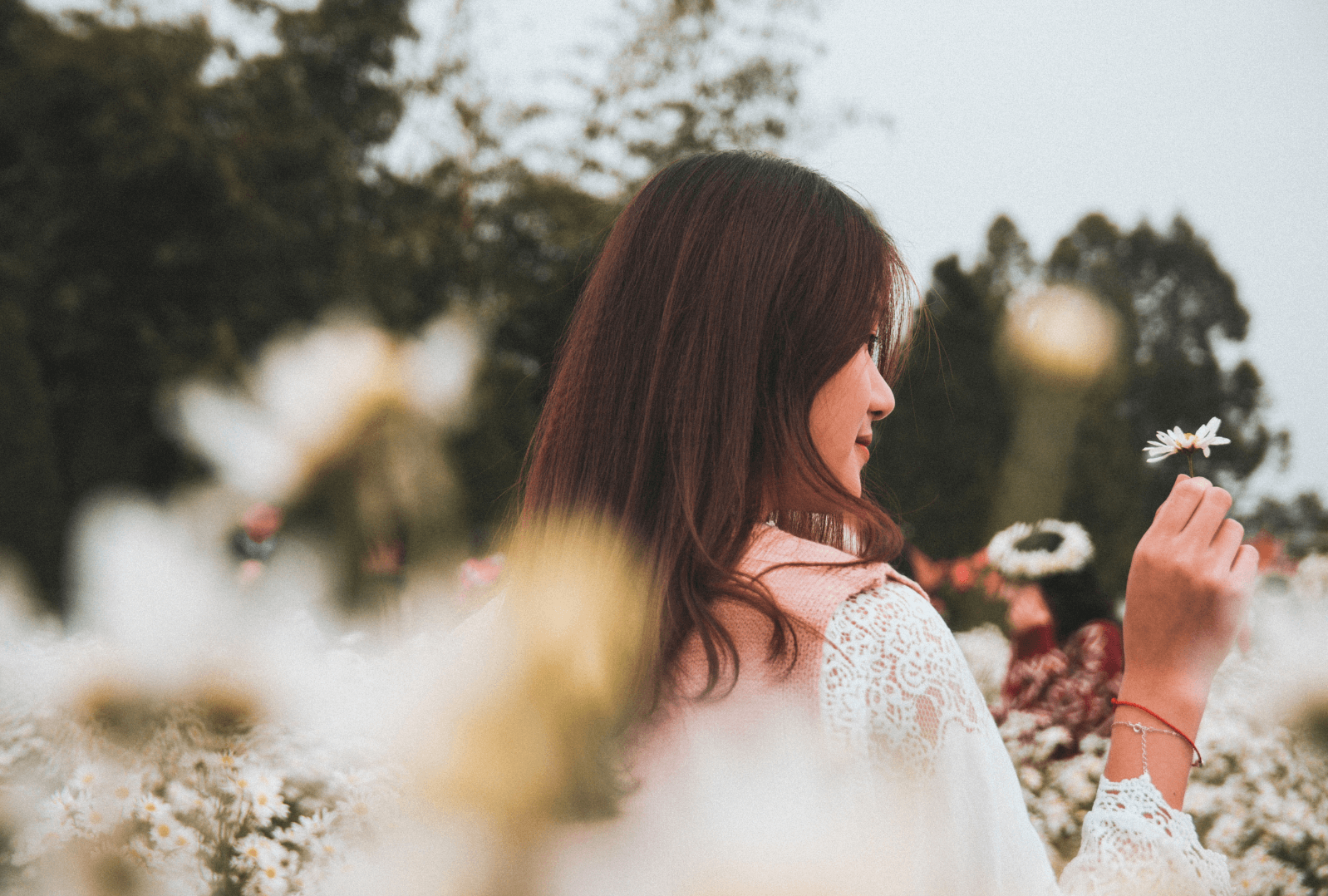 A woman in a field of white flowers practicing mindfulness to manage depression