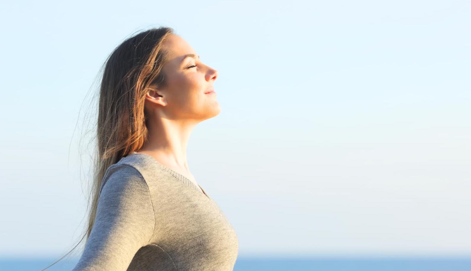 A woman practicing mindful breathing techniques for anxiety relief.